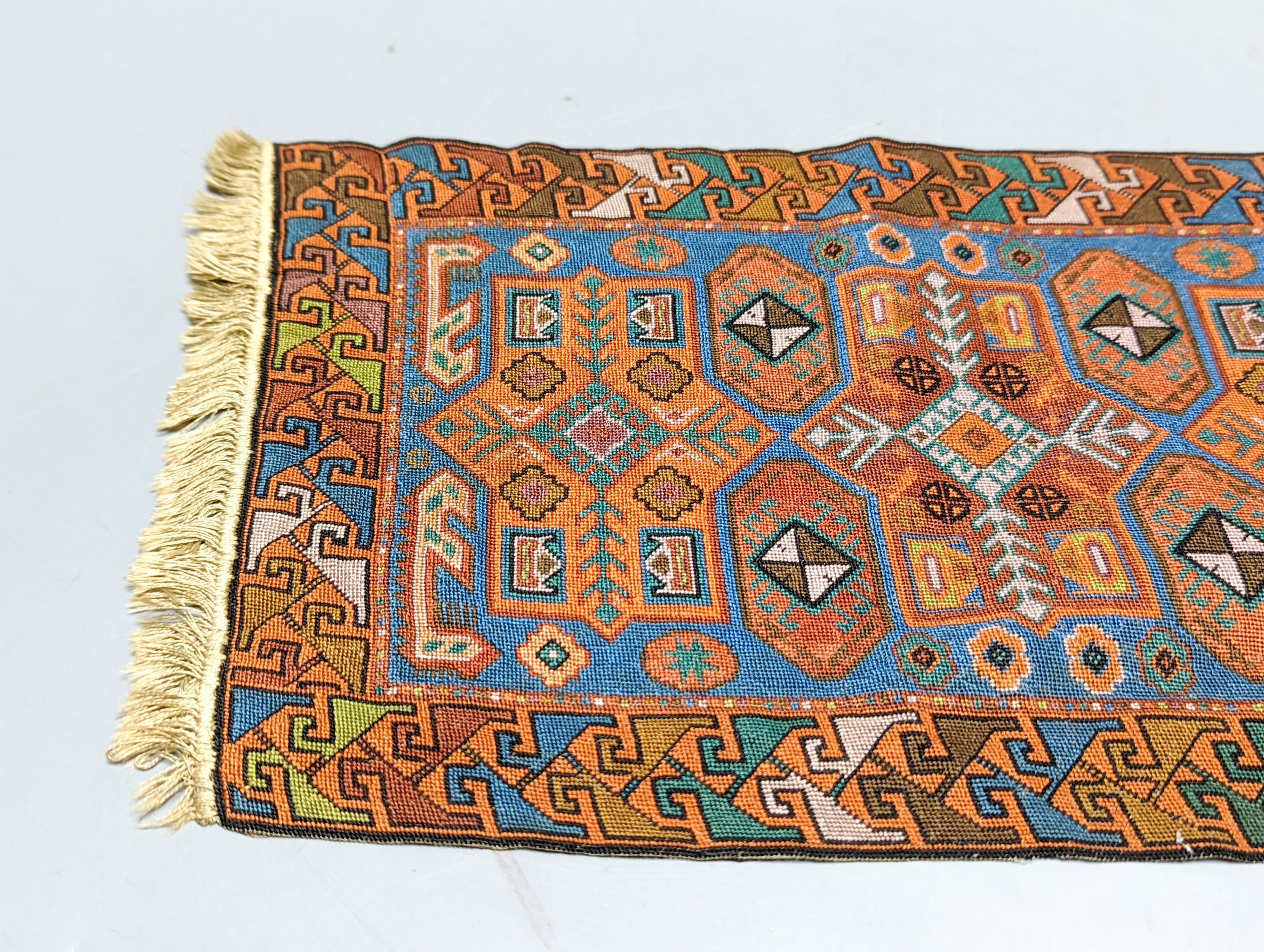A Caucasian style petit point miniature rug 33x20cm